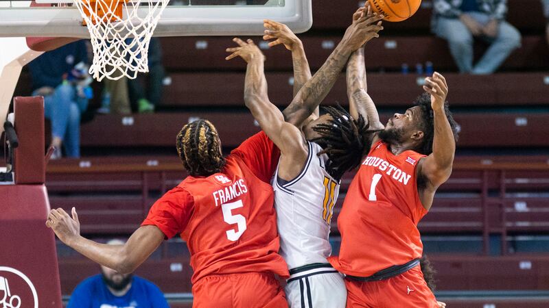 Houston's Ja'Vier Francis (5) and Jamal Shead (1) challenge the shot of Towson's Mekhi Lowery...