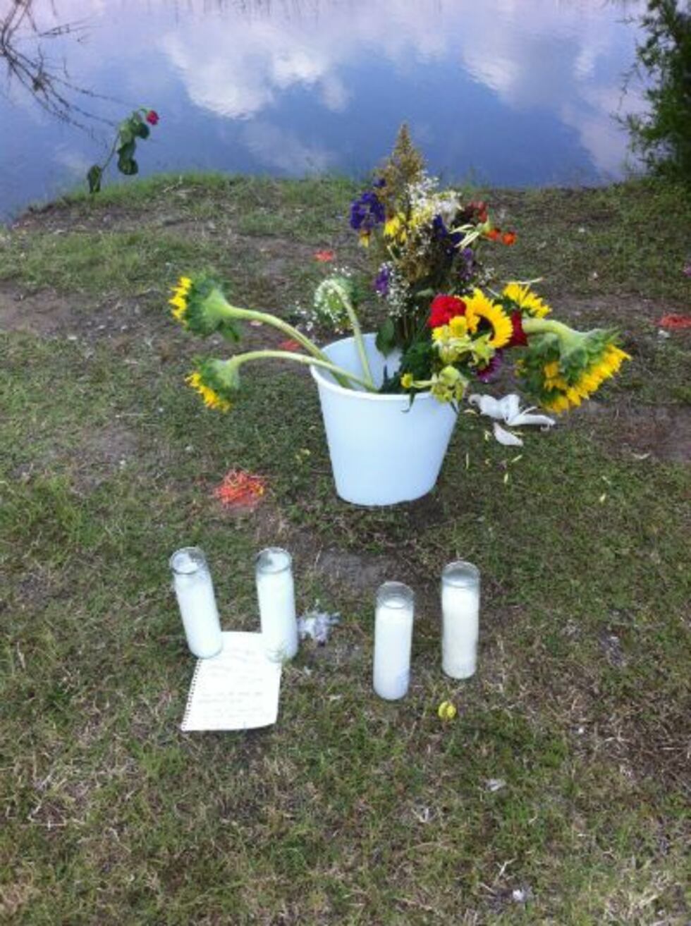 Flowers, four candles, and a note were placed at the edge of the creek.