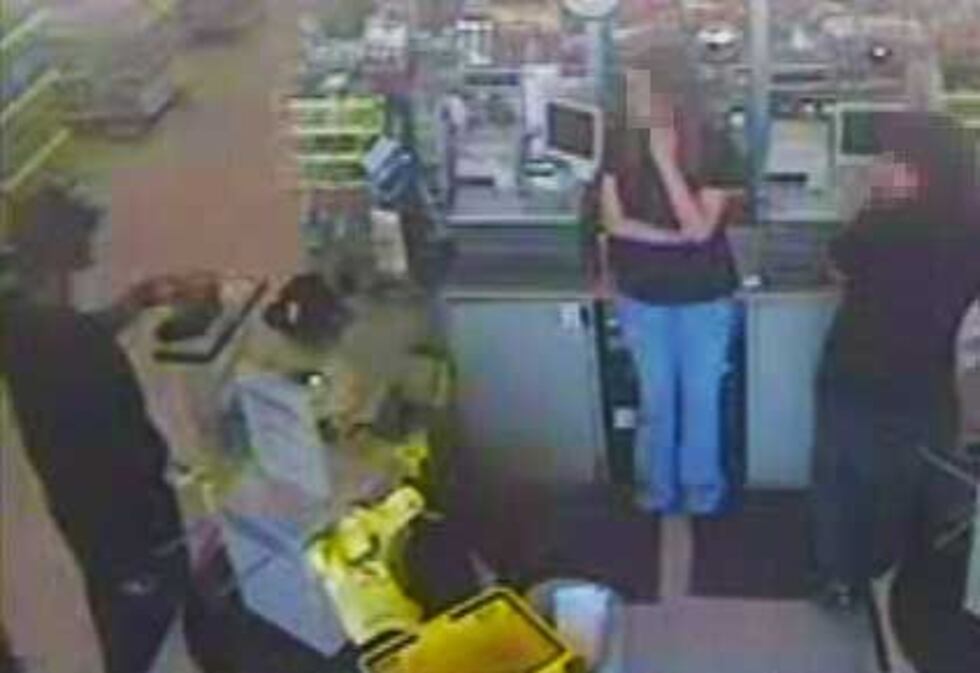 One of the suspects demanding money at the Dollar General.