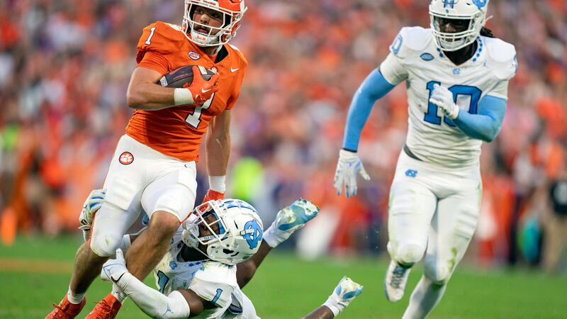 North Carolina defensive back Antavious Lane, bottom left, tries to tackle Clemson running...