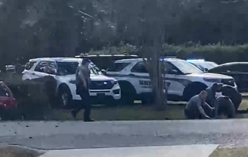 Law enforcement units taking someone into custody following a chase that ended in a crash in...